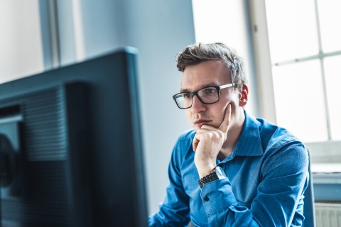 Businessman wearing eyeglasses sitting at his desk