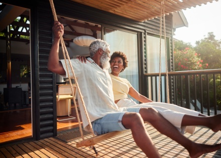 Couple laughing on a porch swing while celebrating a public holiday in Kenya