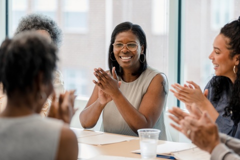 Group of employees smiling and clapping while celebrating workplace culture in Fiji