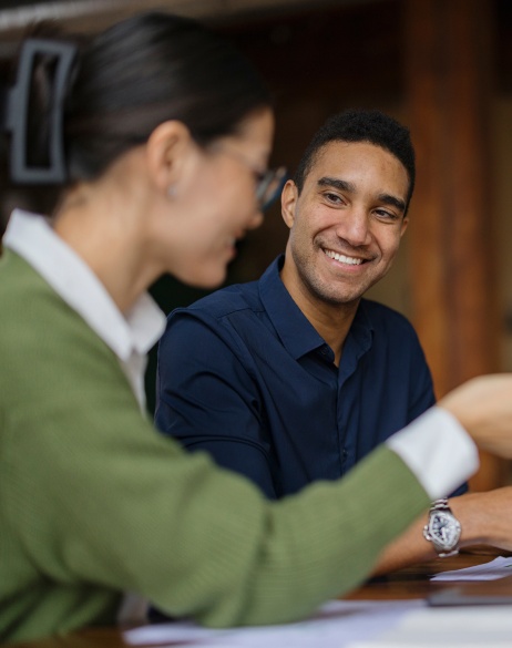 Man and woman smiling looking over data