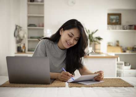 Smiling young woman working on payroll taxes in Lithuania
