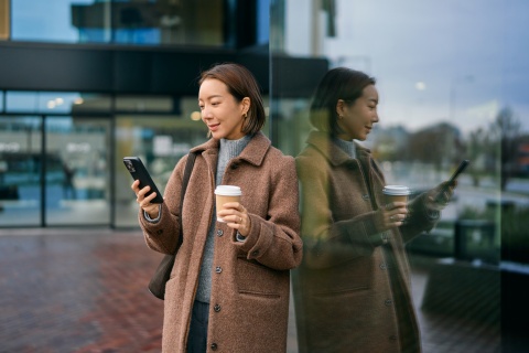 Woman using her smartphone and drinking coffee in Equatorial Guinea