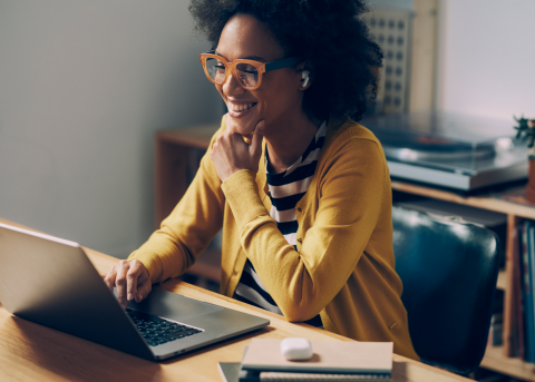 HR manager reviewing an employment contract for a new hire on her laptop in her home office